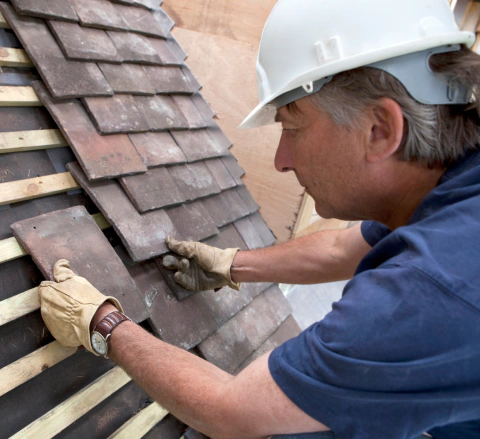 close up worker laying roof tiles